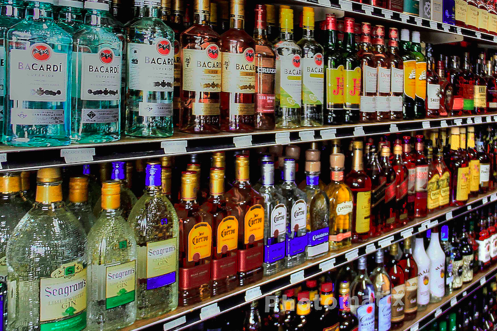 A shelf filled with lots of different types of alcohol.